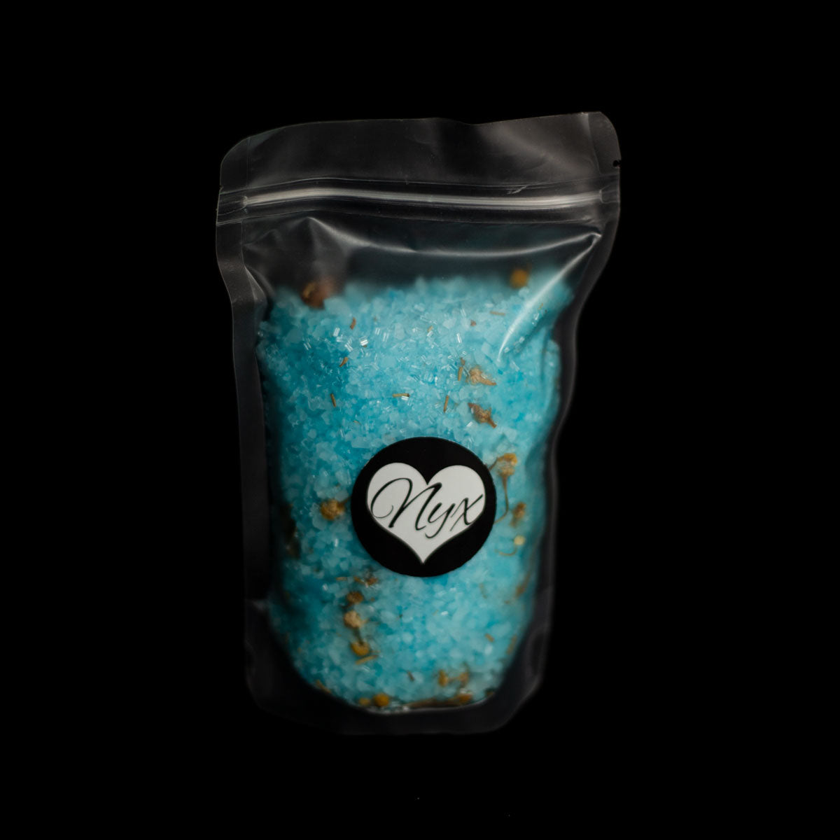 A clear/frosted bag filled with blue bath salts with botanicals