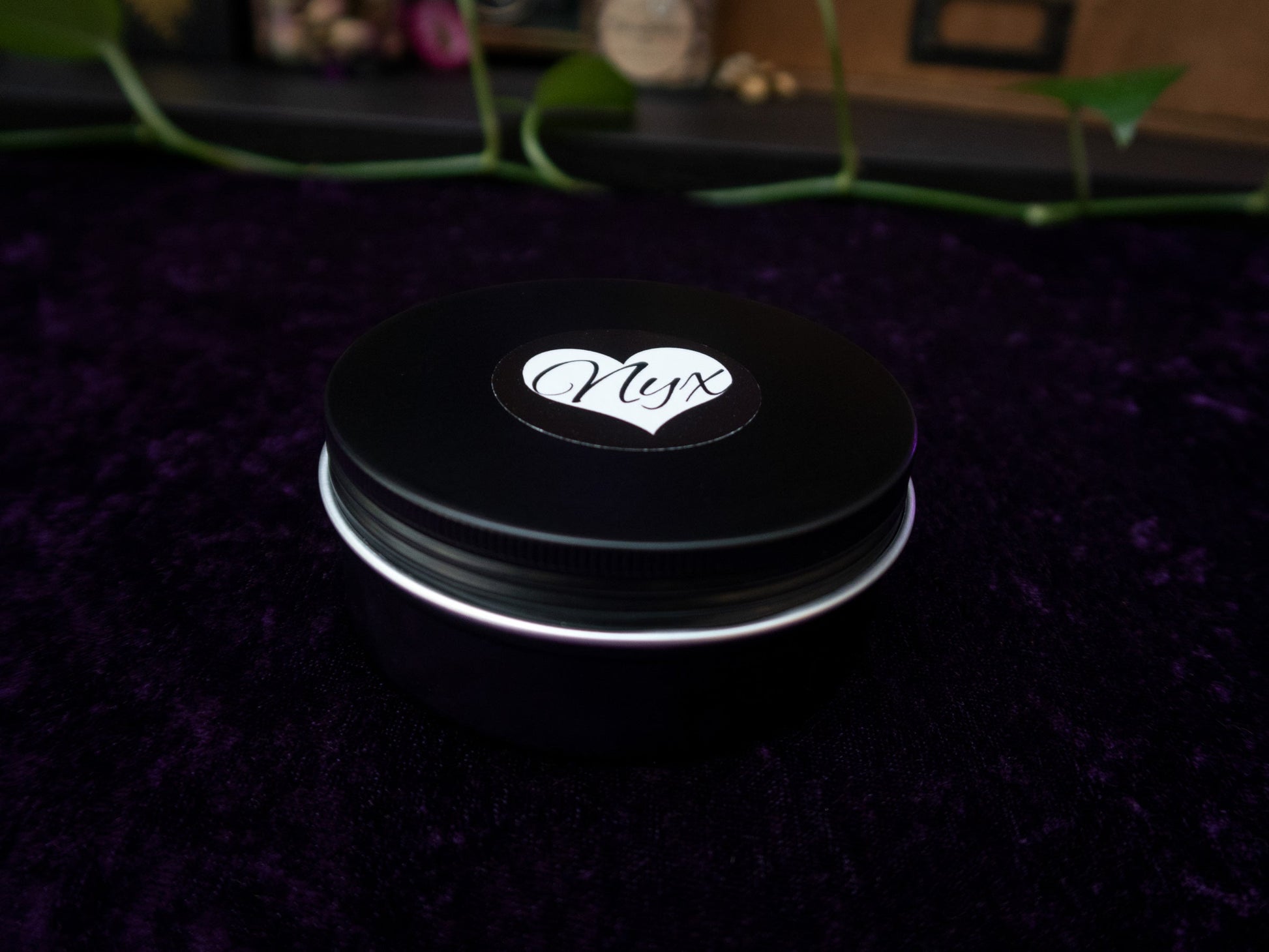 A black candle tin with the lid on.
